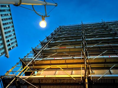 Scaffolding on building against a dark blue sky.